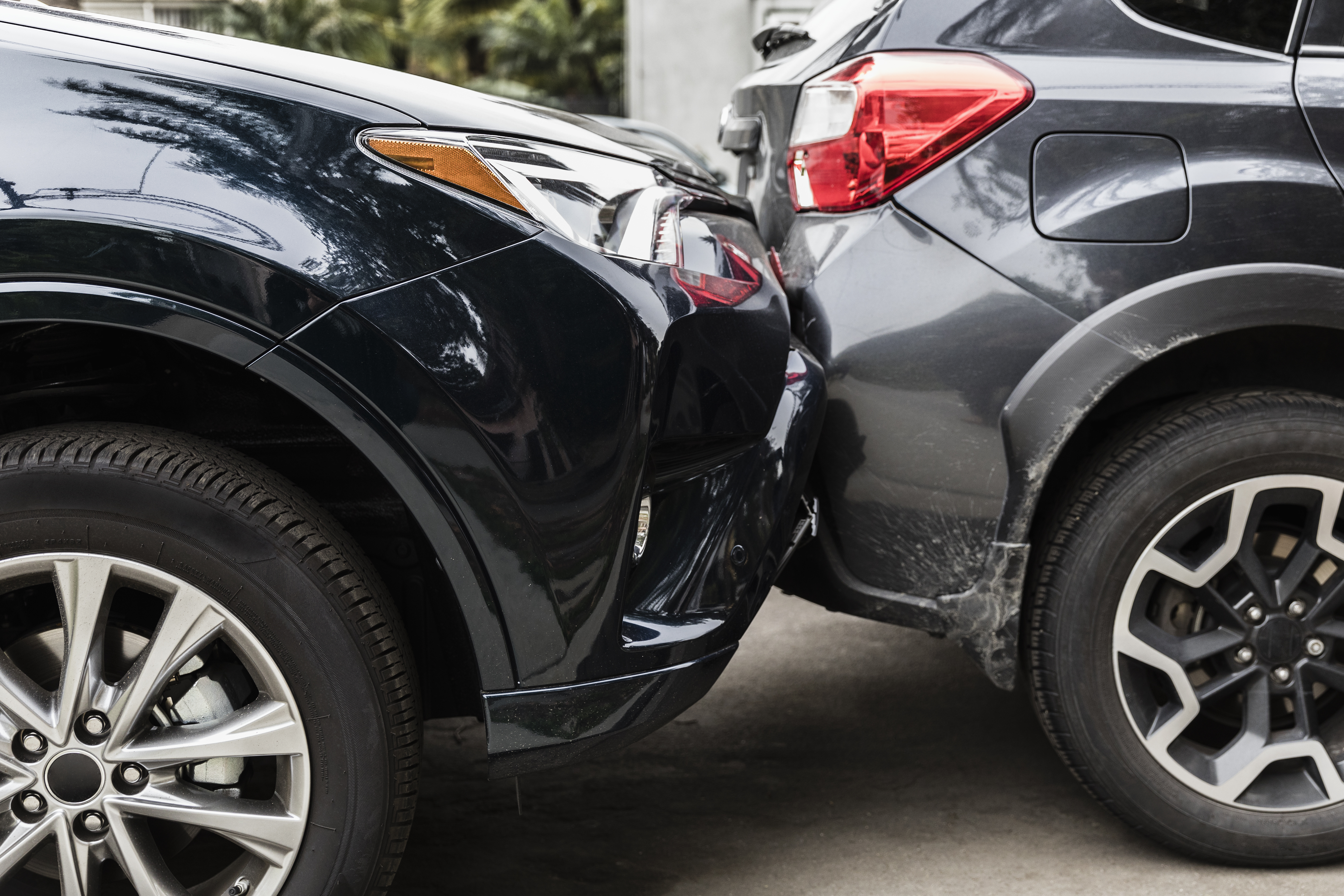 Black car hitting grey car from behind